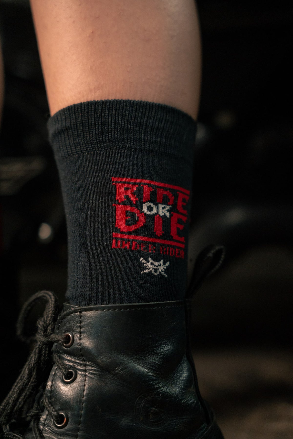 Detalhe da escrita Ride or Die na meia preta